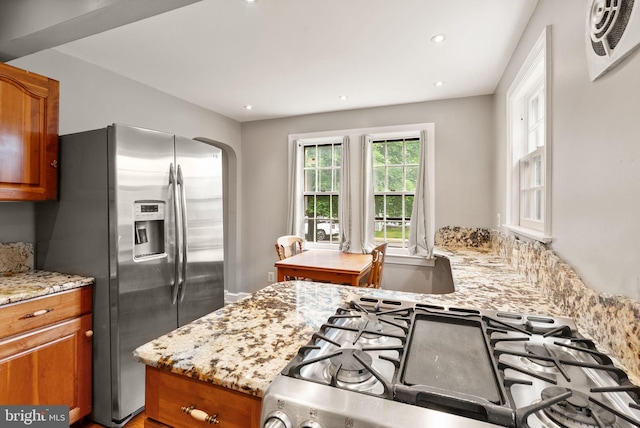 416 S Adams St, Arlington, VA 22204 - kitchen featuring appliances with stainless steel finishes, brown cabinets, light stone counters, arched walkways, and recessed lighting