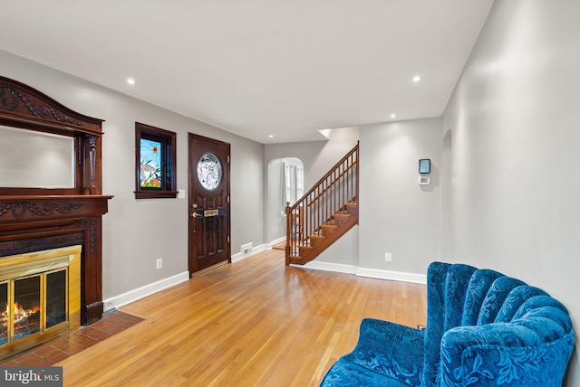 416 S Adams St, Arlington, VA 22204 - living area with arched walkways, wood finished floors, stairway, a fireplace with flush hearth, and baseboards