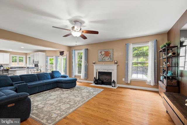 10701 Monocacy Way, Manassas, VA 20112 - living area featuring a ceiling fan, light wood-style floors, a fireplace, and baseboards