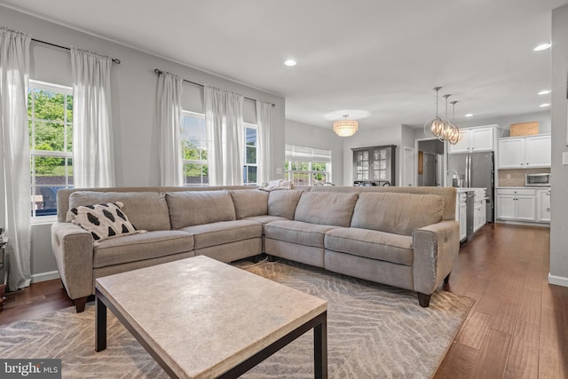 living room with healthy amount of natural light, recessed lighting, and dark wood-type flooring