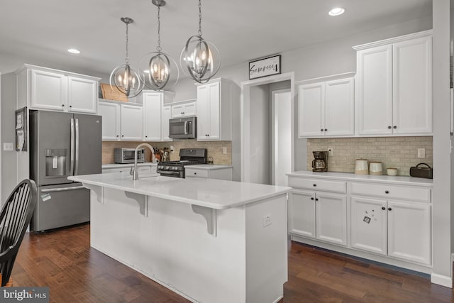 kitchen featuring stainless steel appliances, a chandelier, backsplash, white cabinetry, and recessed lighting