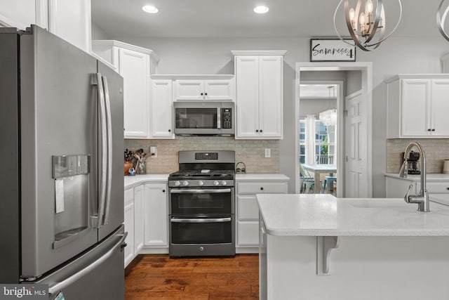 kitchen featuring stainless steel appliances, white cabinets, recessed lighting, backsplash, and dark wood finished floors