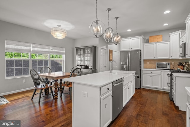 kitchen featuring appliances with stainless steel finishes, recessed lighting, light countertops, decorative backsplash, and a chandelier