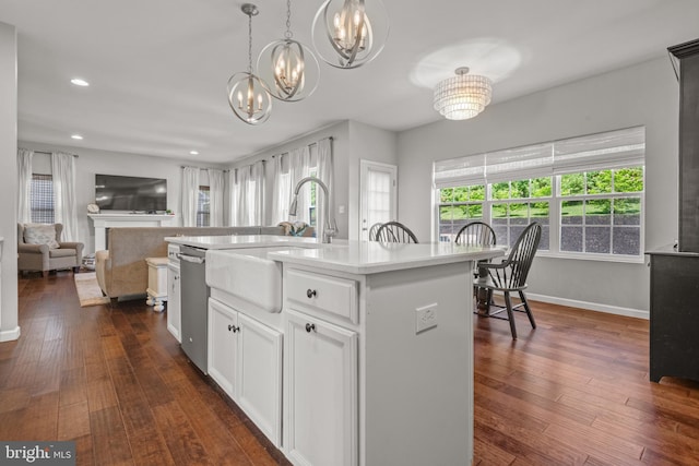 kitchen with a sink, stainless steel dishwasher, a chandelier, dark wood-style flooring, and recessed lighting