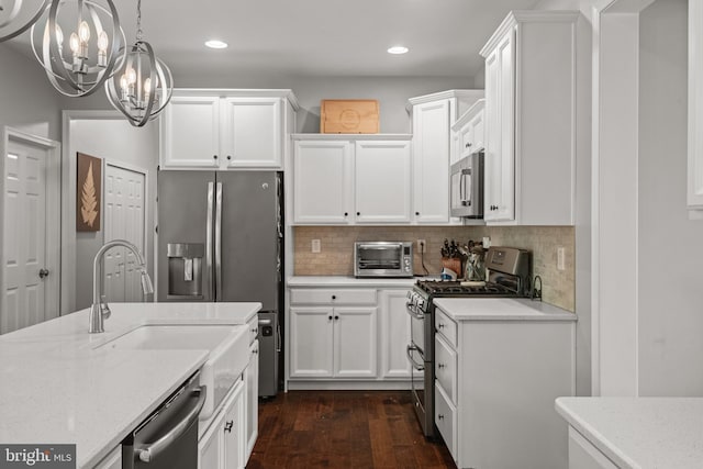 kitchen featuring stainless steel appliances, a chandelier, dark wood-type flooring, white cabinets, and recessed lighting