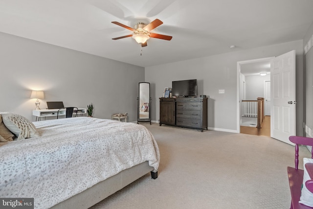 bedroom featuring light carpet, a ceiling fan, and baseboards