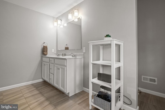 bathroom with baseboards and double vanity