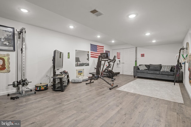 exercise room with wood finished floors and recessed lighting