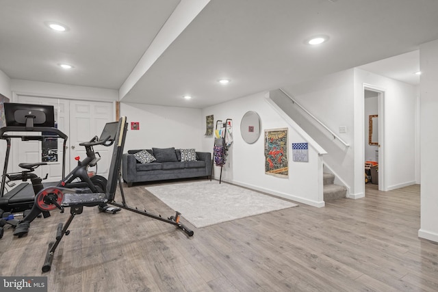 exercise room featuring baseboards, wood finished floors, and recessed lighting