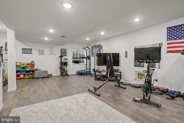 workout room featuring wood finished floors, recessed lighting, and baseboards