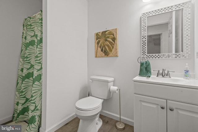full bath featuring baseboards, toilet, wood finished floors, and vanity