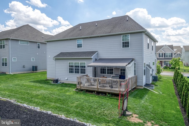 back of house featuring central AC, a deck, and a yard