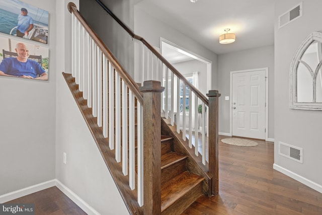 staircase featuring wood finished floors and baseboards