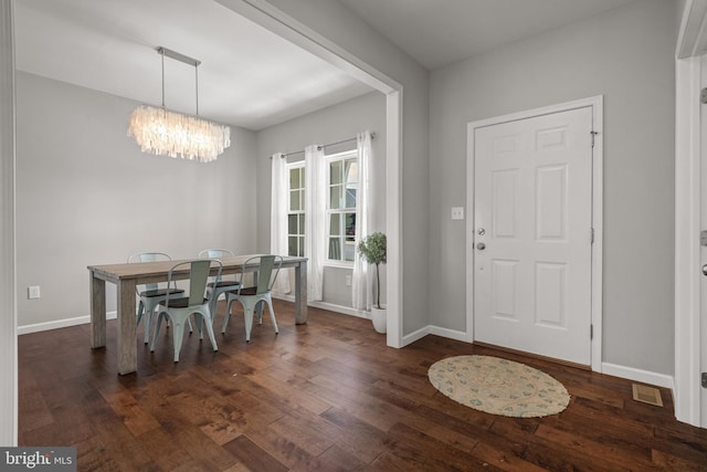 dining area with a chandelier, dark wood finished floors, and baseboards