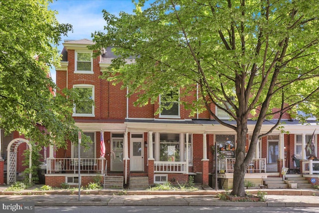 view of front of house featuring covered porch and brick siding