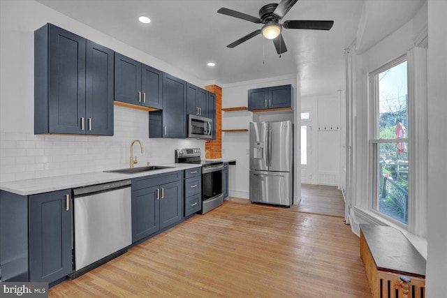kitchen with appliances with stainless steel finishes, a sink, healthy amount of natural light, light countertops, and recessed lighting