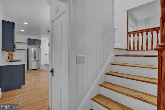 staircase featuring wood finished floors, recessed lighting, and a ceiling fan