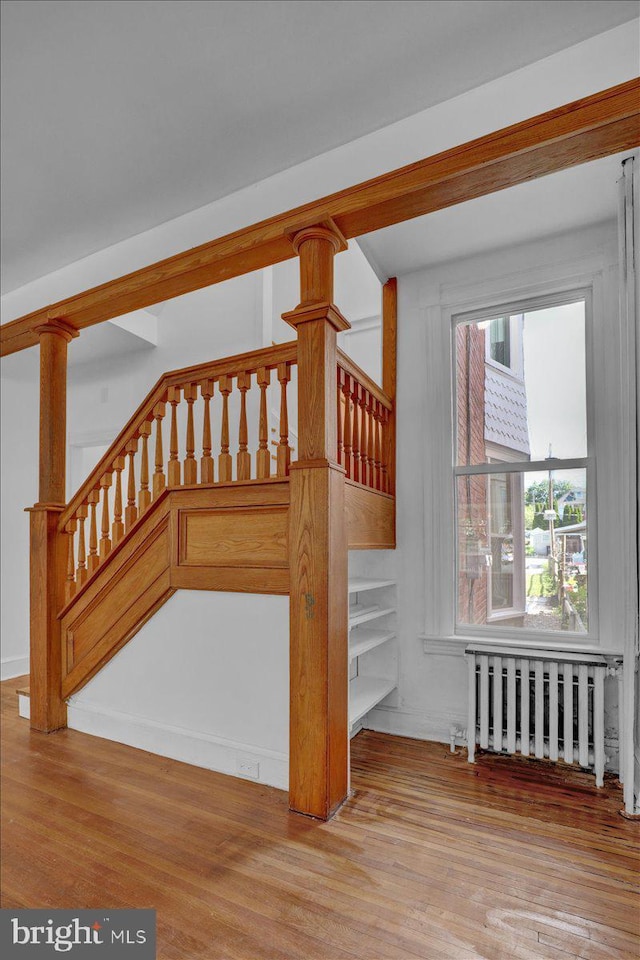 staircase featuring radiator and wood finished floors