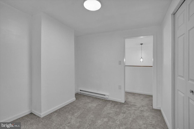 carpeted empty room with baseboard heating and baseboards