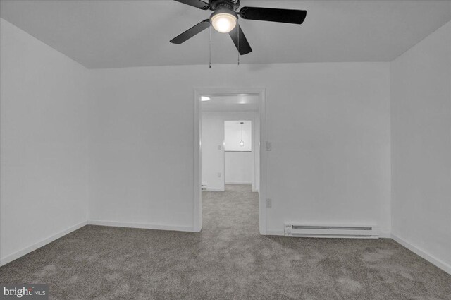 empty room with baseboard heating, carpet, a ceiling fan, and baseboards