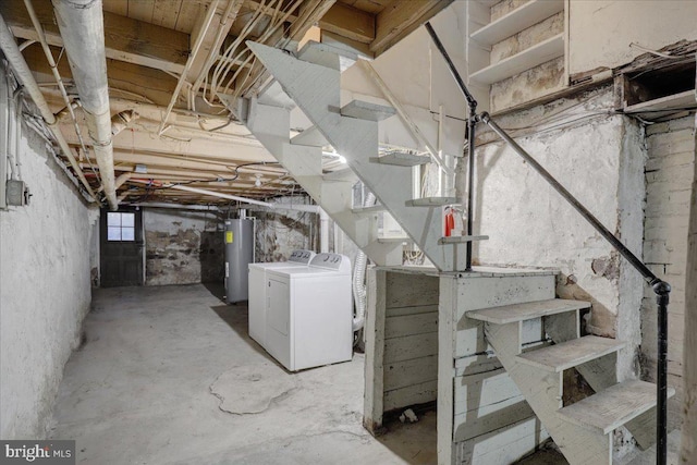 below grade area with electric water heater, stairway, and washer and clothes dryer