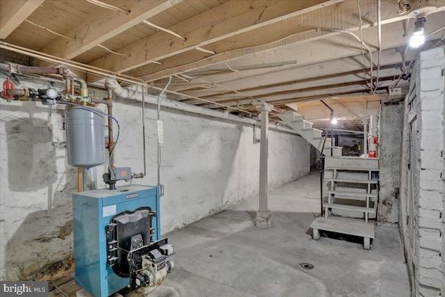 unfinished basement featuring a heating unit and stairway