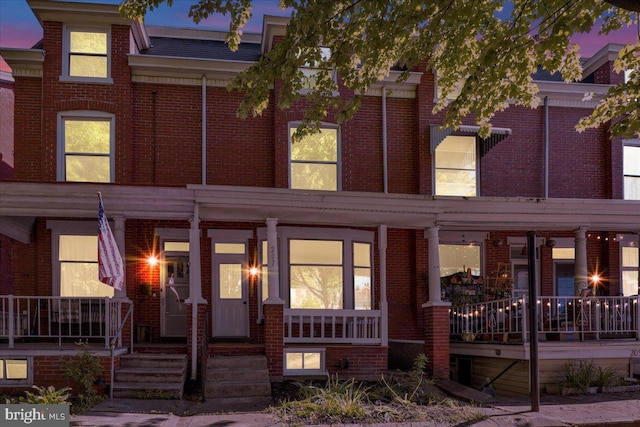 view of front facade featuring covered porch and brick siding