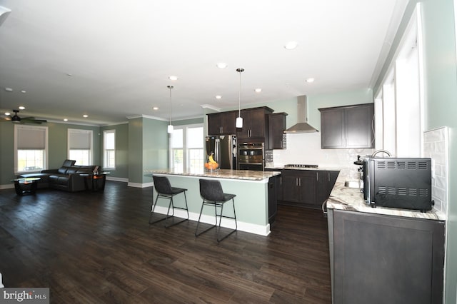 41 Green Dome Pl, Gaithersburg, MD 20878 - kitchen with wall chimney range hood, stainless steel appliances, dark brown cabinetry, a center island, and a breakfast bar