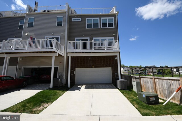 41 Green Dome Pl, Gaithersburg, MD 20878 - rear view of house featuring cooling unit, a garage, driveway, brick siding, and a wooden deck