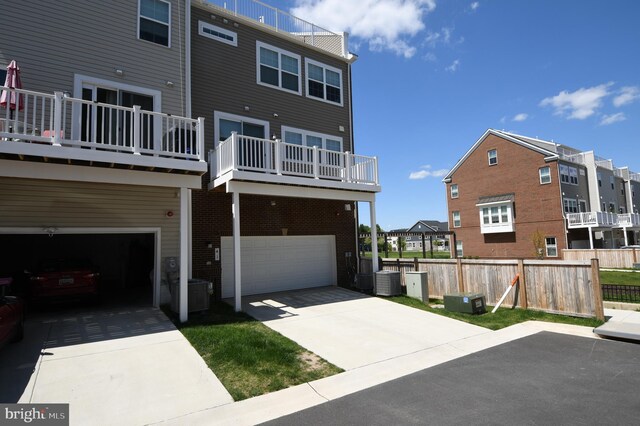 41 Green Dome Pl, Gaithersburg, MD 20878 - back of house with a garage, a residential view, a balcony, fence, and driveway