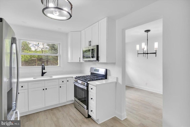 200 Boxwood Ln, Cinnaminson, NJ 08077 - kitchen with stainless steel appliances, a sink, a chandelier, light countertops, and white cabinetry