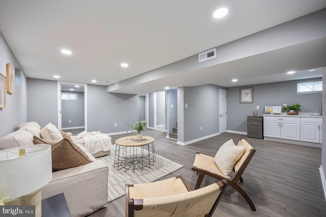 living room featuring recessed lighting, dark wood-style flooring, stairs, baseboards, and healthy amount of natural light