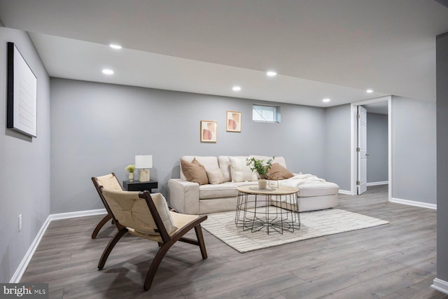 living room with wood finished floors, baseboards, and recessed lighting