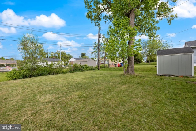 view of green lawn featuring a storage unit and an outbuilding