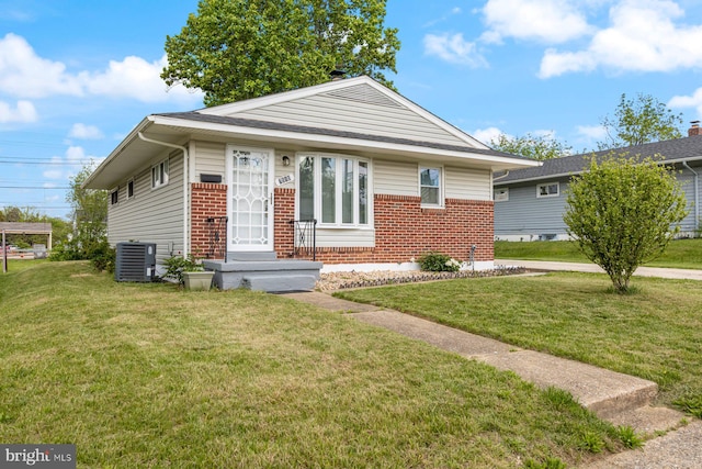 bungalow featuring brick siding, a front lawn, and cooling unit