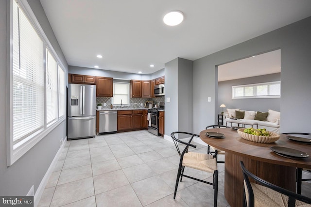 kitchen featuring stainless steel appliances, decorative backsplash, plenty of natural light, light tile patterned floors, and recessed lighting