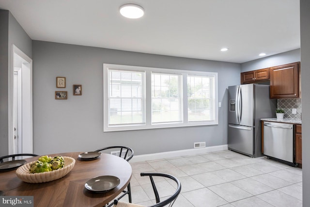 kitchen with appliances with stainless steel finishes, decorative backsplash, baseboards, light tile patterned floors, and recessed lighting