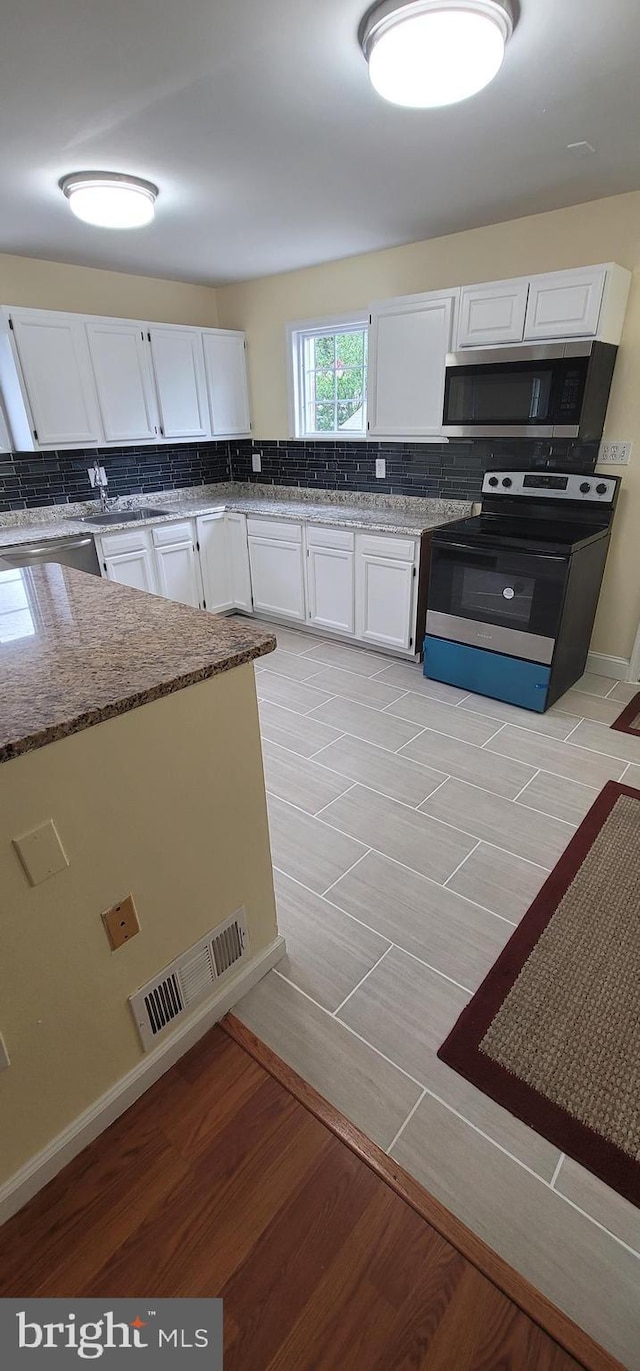 16620 Galt Ct, Woodbridge, VA 22191 - kitchen featuring stainless steel microwave, electric range oven, white cabinetry, and stone countertops