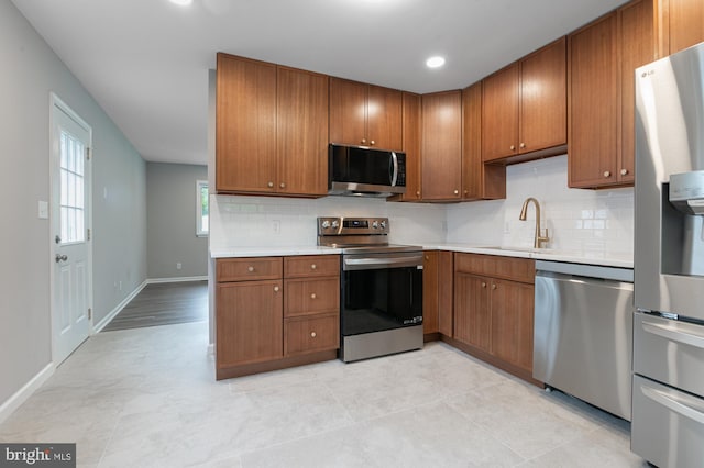 609 6th Ave, Brunswick, MD 21716 - kitchen featuring appliances with stainless steel finishes, light countertops, backsplash, brown cabinets, and recessed lighting