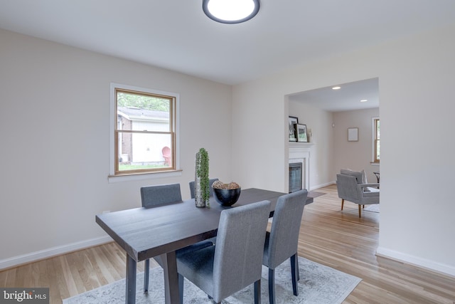7923 Karl Rd, Alexandria, VA 22308 - dining space with light wood-type flooring, baseboards, a glass covered fireplace, and recessed lighting