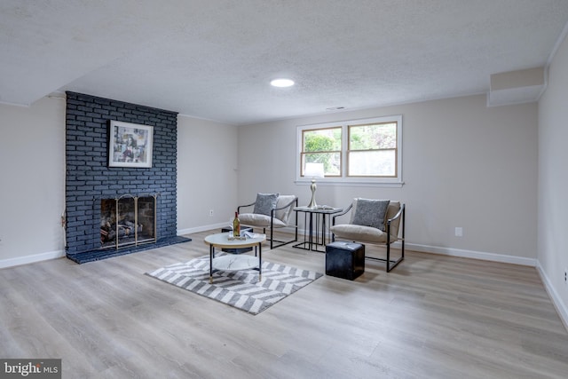 7923 Karl Rd, Alexandria, VA 22308 - sitting room with wood finished floors, a textured ceiling, baseboards, and a brick fireplace