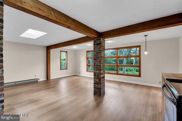 305 Nautilus Blvd, Forked River, NJ 08731 - unfurnished living room featuring a baseboard radiator, ornate columns, wood finished floors, baseboards, and a skylight