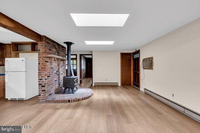 305 Nautilus Blvd, Forked River, NJ 08731 - living room featuring a baseboard radiator, a wood stove, wood finished floors, and a skylight