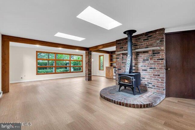 305 Nautilus Blvd, Forked River, NJ 08731 - unfurnished living room with a wood stove, wood finished floors, a skylight, and beamed ceiling
