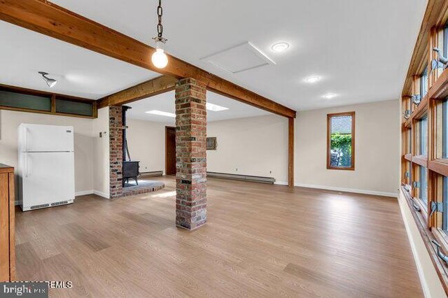 305 Nautilus Blvd, Forked River, NJ 08731 - basement with freestanding refrigerator, a baseboard radiator, a wood stove, and wood finished floors