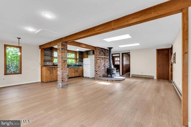 305 Nautilus Blvd, Forked River, NJ 08731 - unfurnished living room with a wood stove, decorative columns, baseboard heating, a baseboard radiator, and wood finished floors