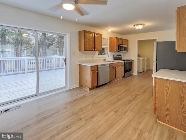 105 Sailor Ln, Milton, DE 19968 - kitchen with appliances with stainless steel finishes, a sink, washer and dryer, ceiling fan, and brown cabinets