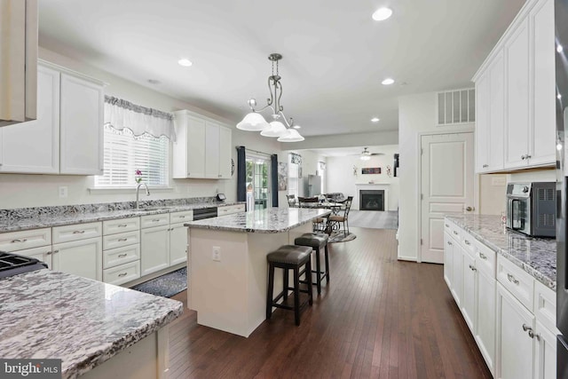 7571 Kindler Overlook Dr, Laurel, MD 20723 - kitchen with open floor plan, a breakfast bar area, white cabinets, a center island, and recessed lighting