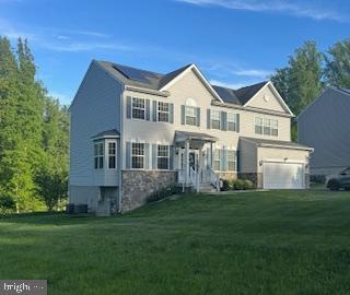 7571 Kindler Overlook Dr, Laurel, MD 20723 - view of front of home featuring a front yard, an attached garage, and stone siding