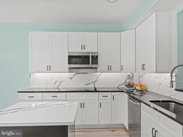 kitchen featuring appliances with stainless steel finishes, a sink, and white cabinets
